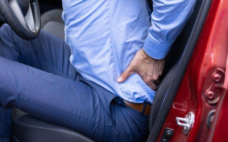 a man in a blue shirt is sitting in a red car
