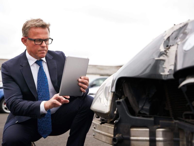 a man in a suit is looking at a laptop