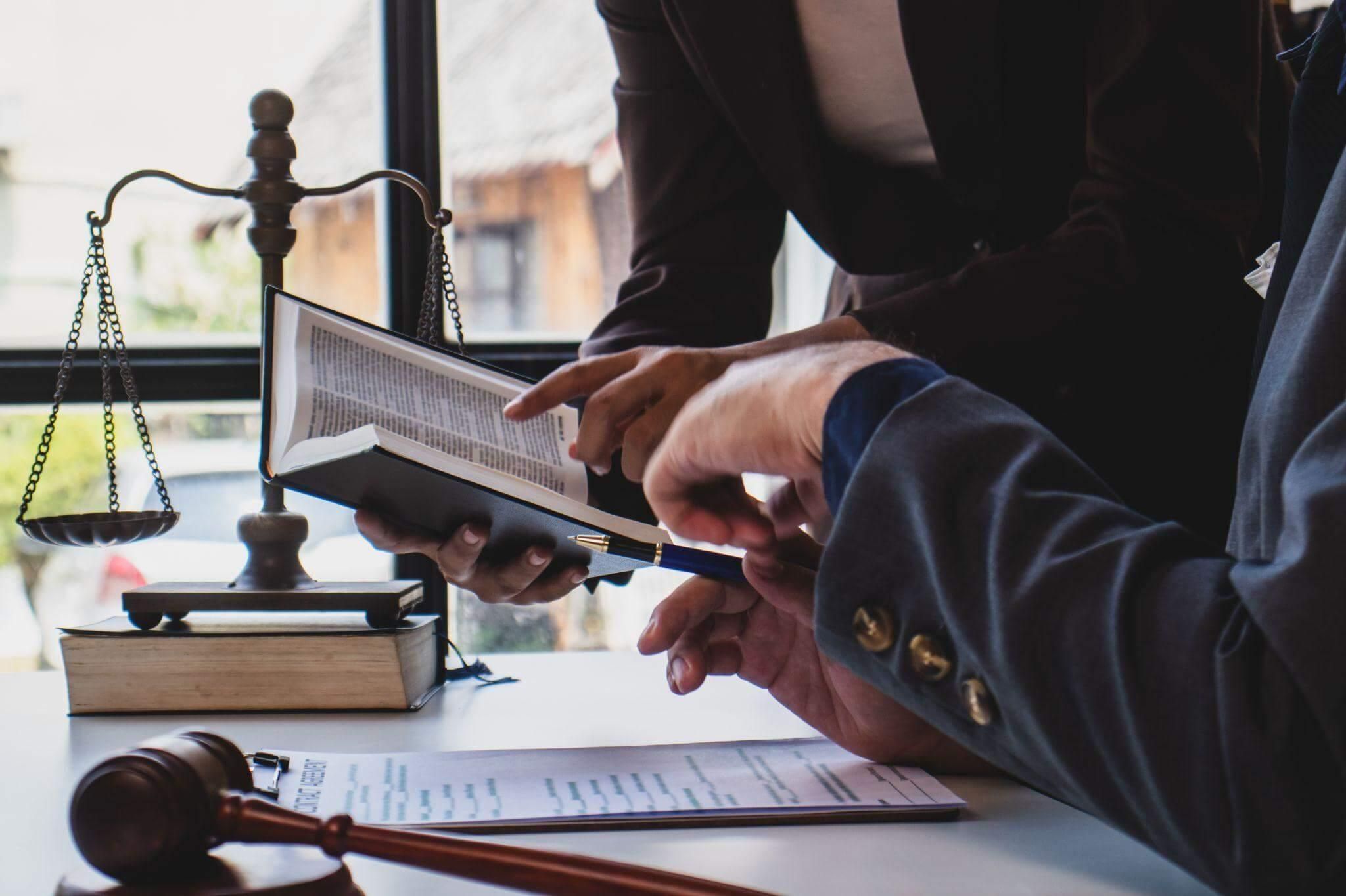 two people sitting at a table in front of a judge