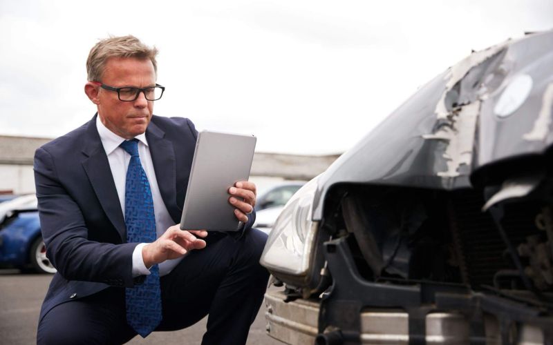 a man in a suit is looking at a laptop