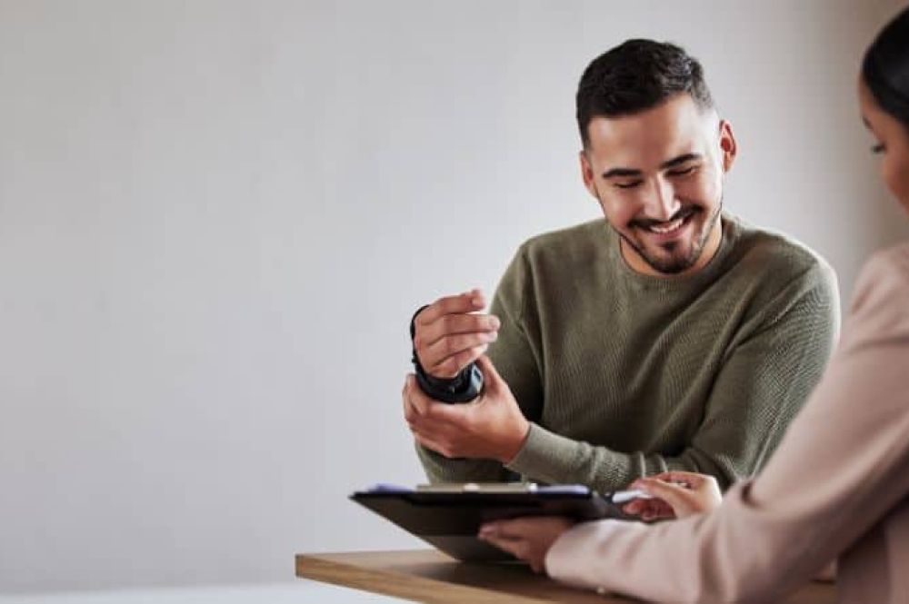 Man holding his wrist in a cast while smiling