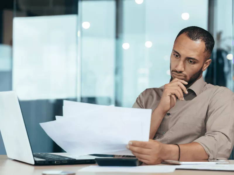 man sitting at a desk reviewing his pain and suffering claim documents