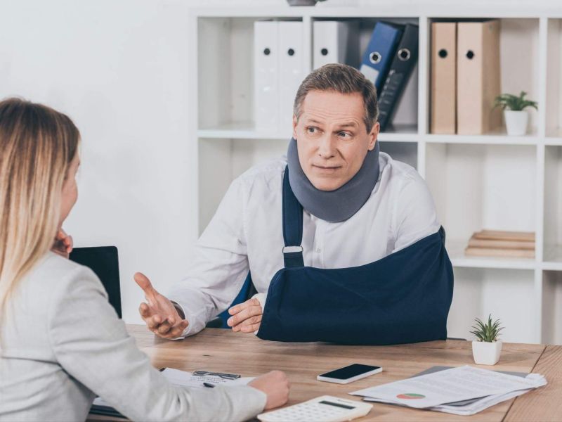 a woman talking to a man in a neck brace