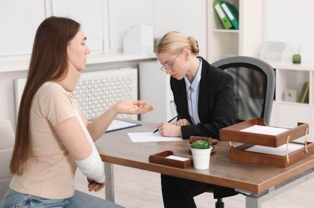 a woman sitting at a desk talking to another woman