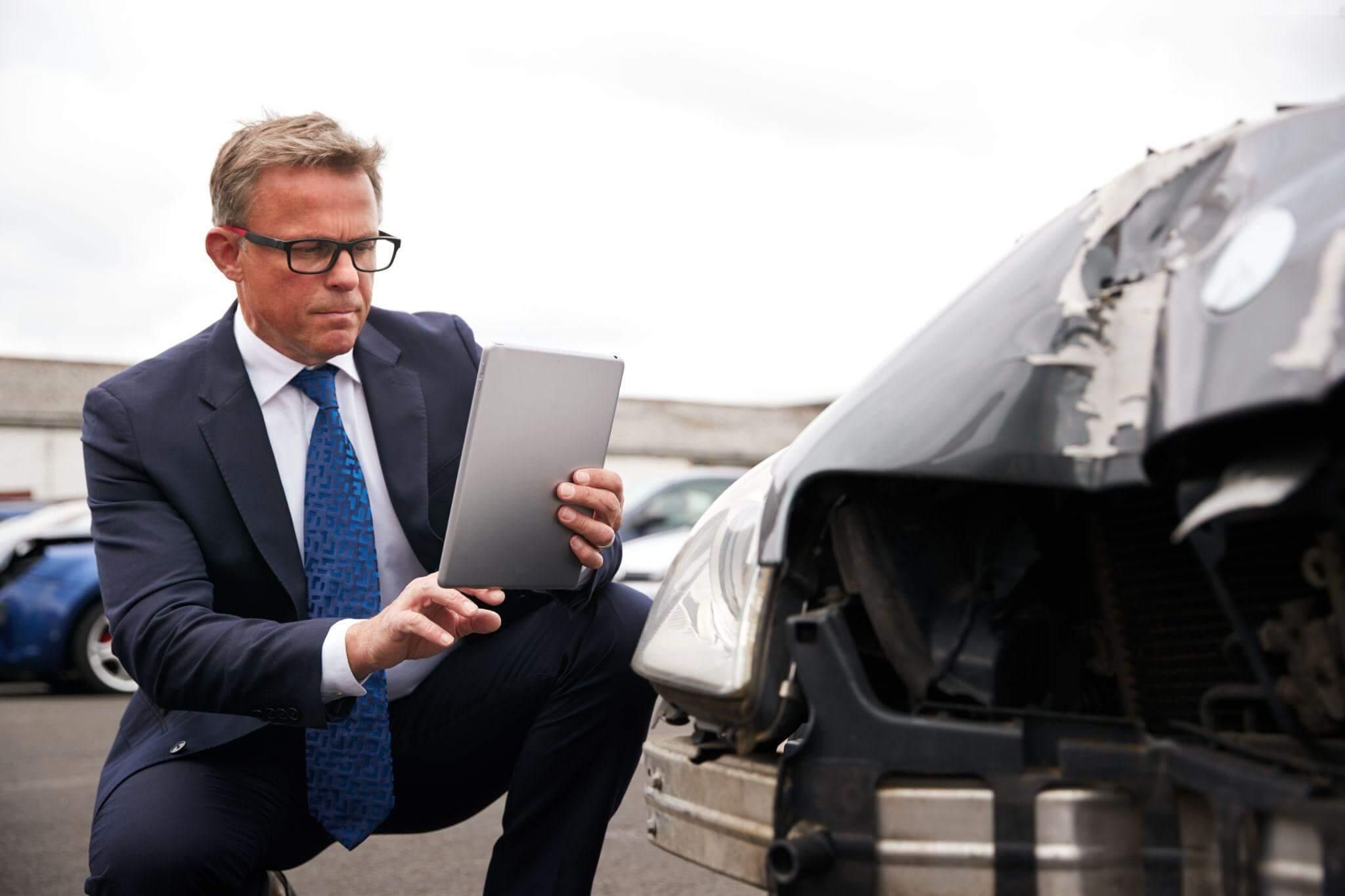 a man in a suit is looking at a laptop