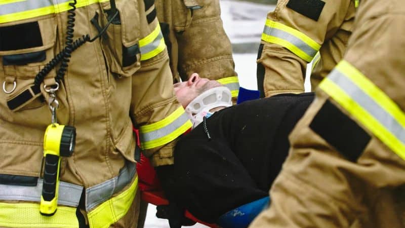 firefighters carrying a man on a stretcher