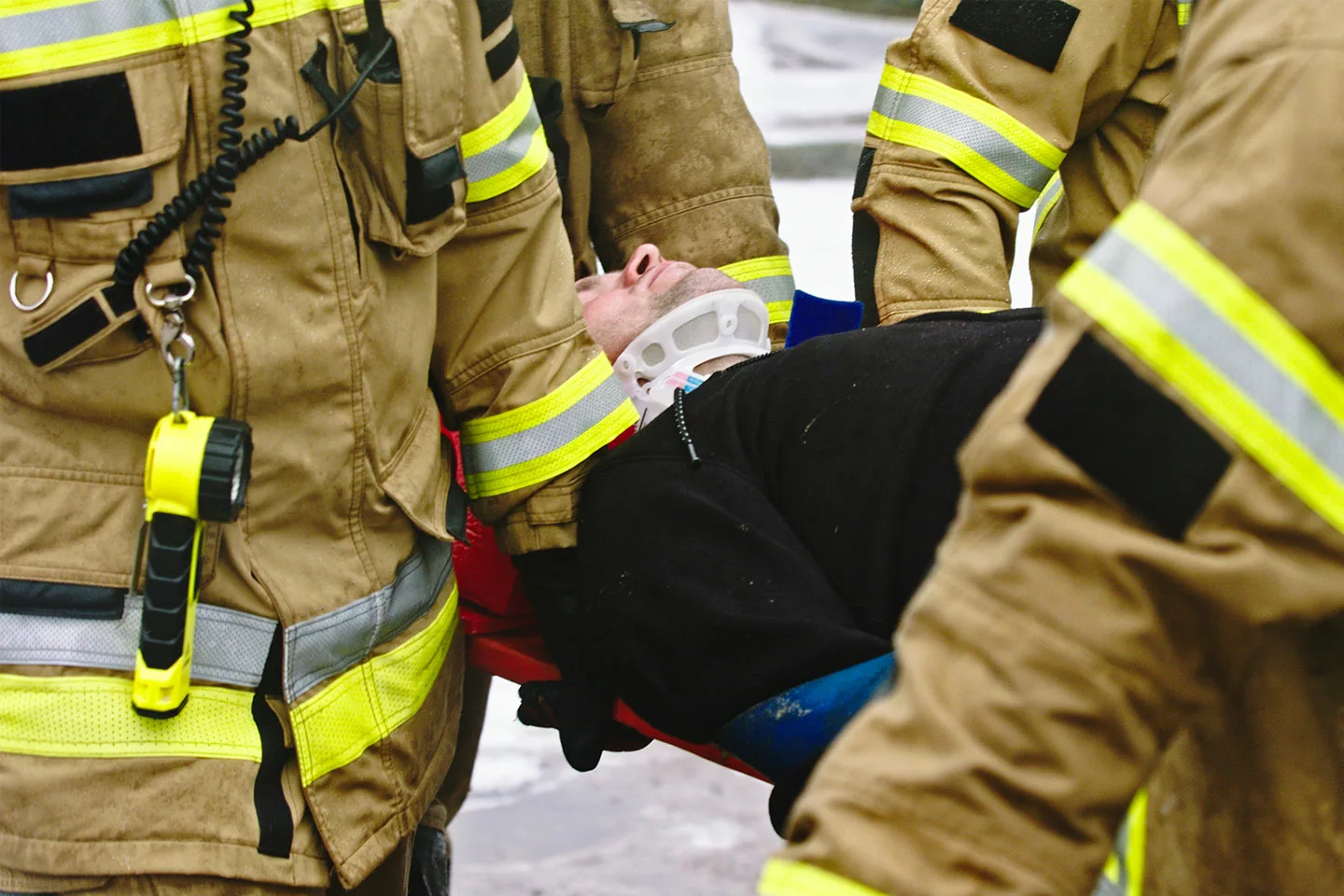 first responders carrying man on stretcher in neck brace