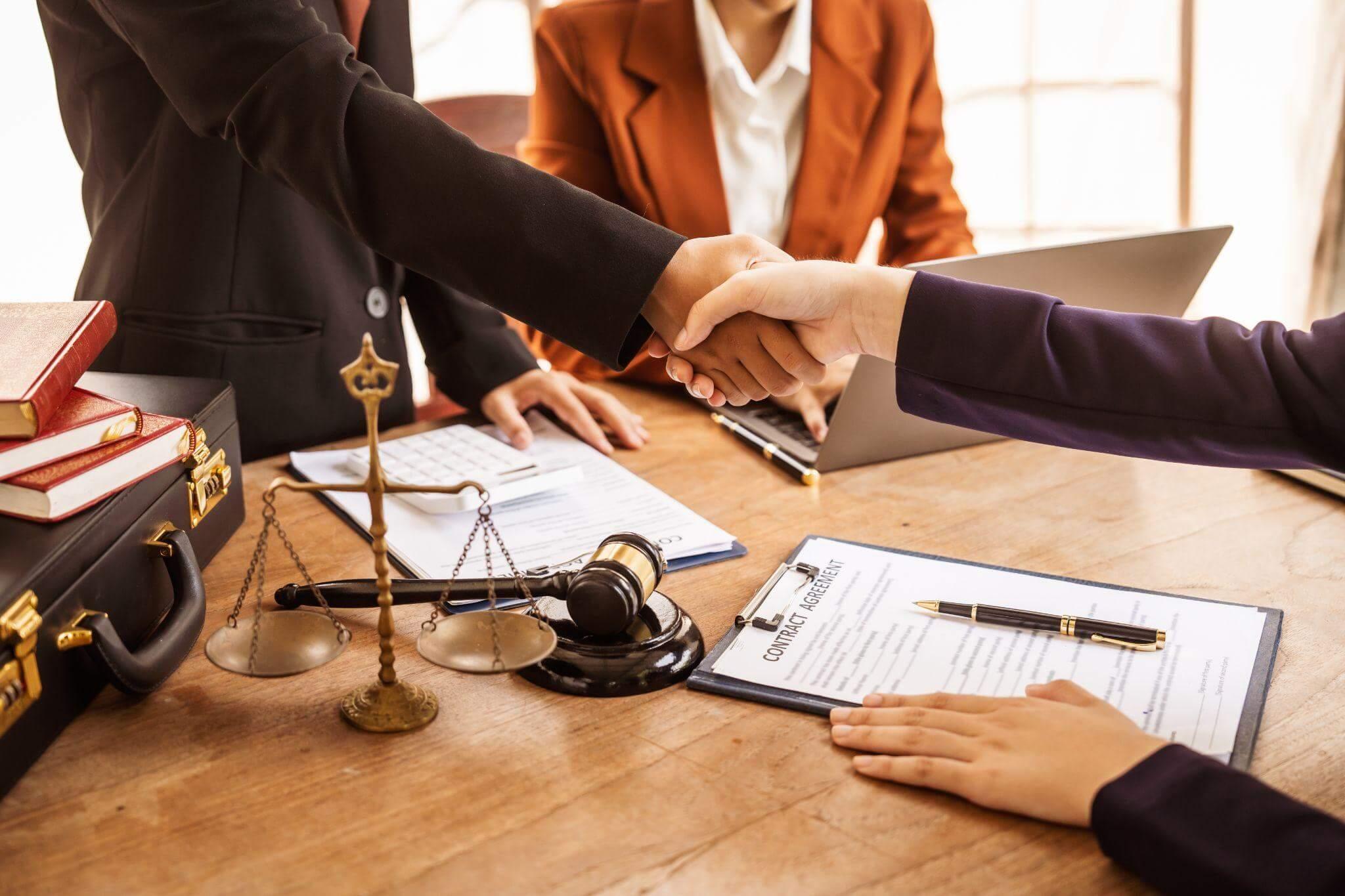 a couple of people shaking hands over a table