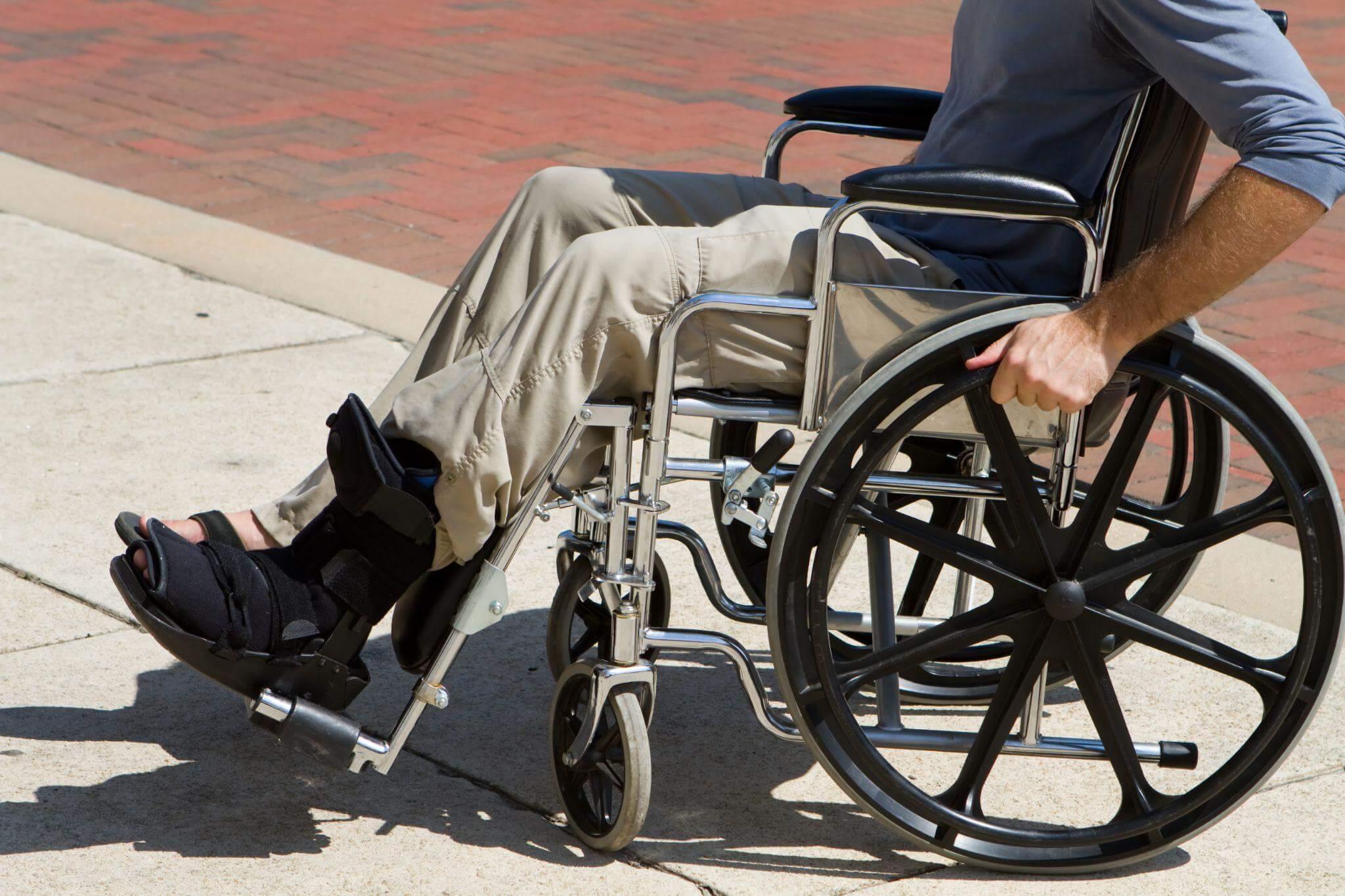 a man sitting in a wheel chair on a sidewalk