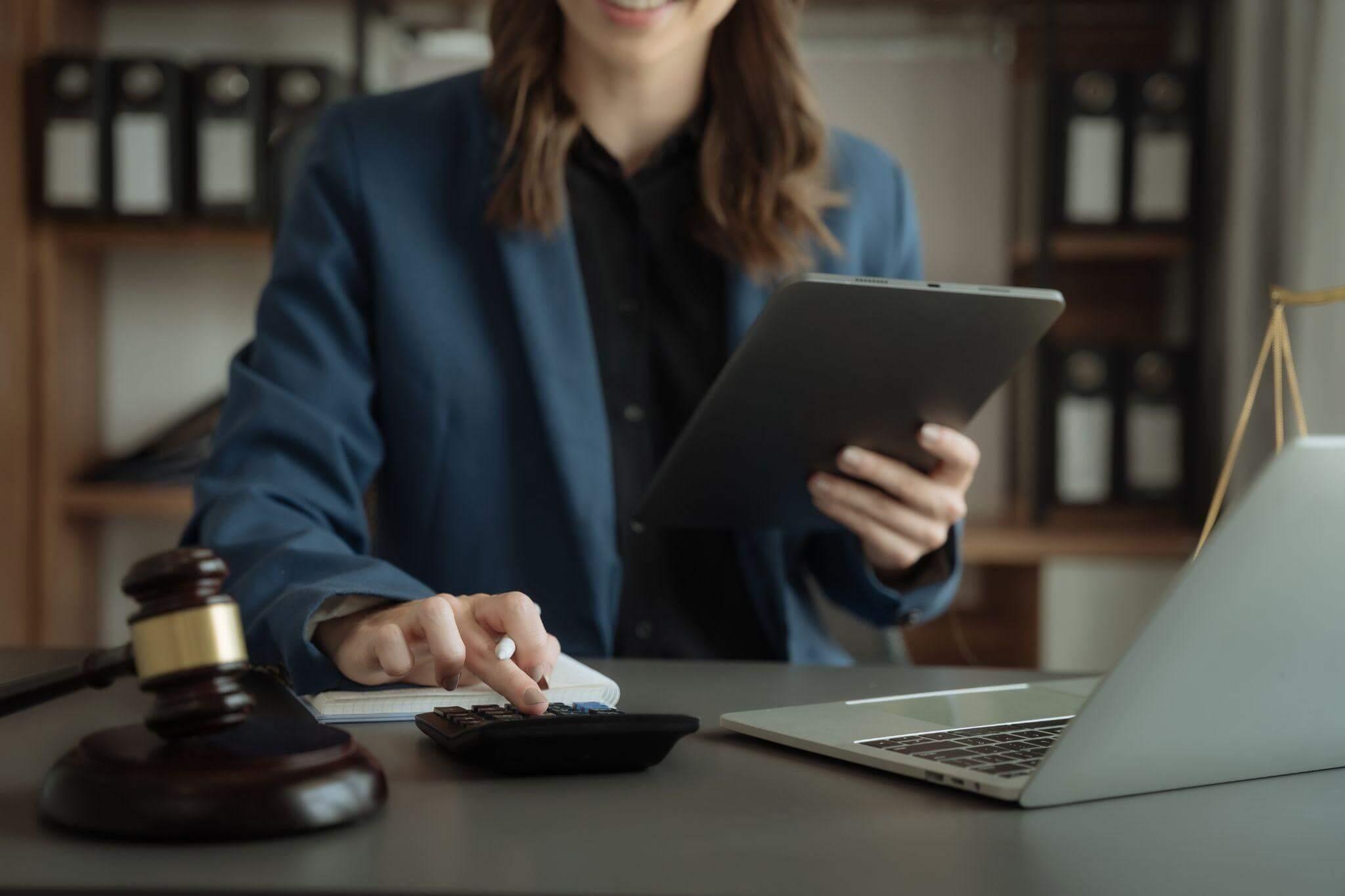a woman sitting at a desk in front of a laptop