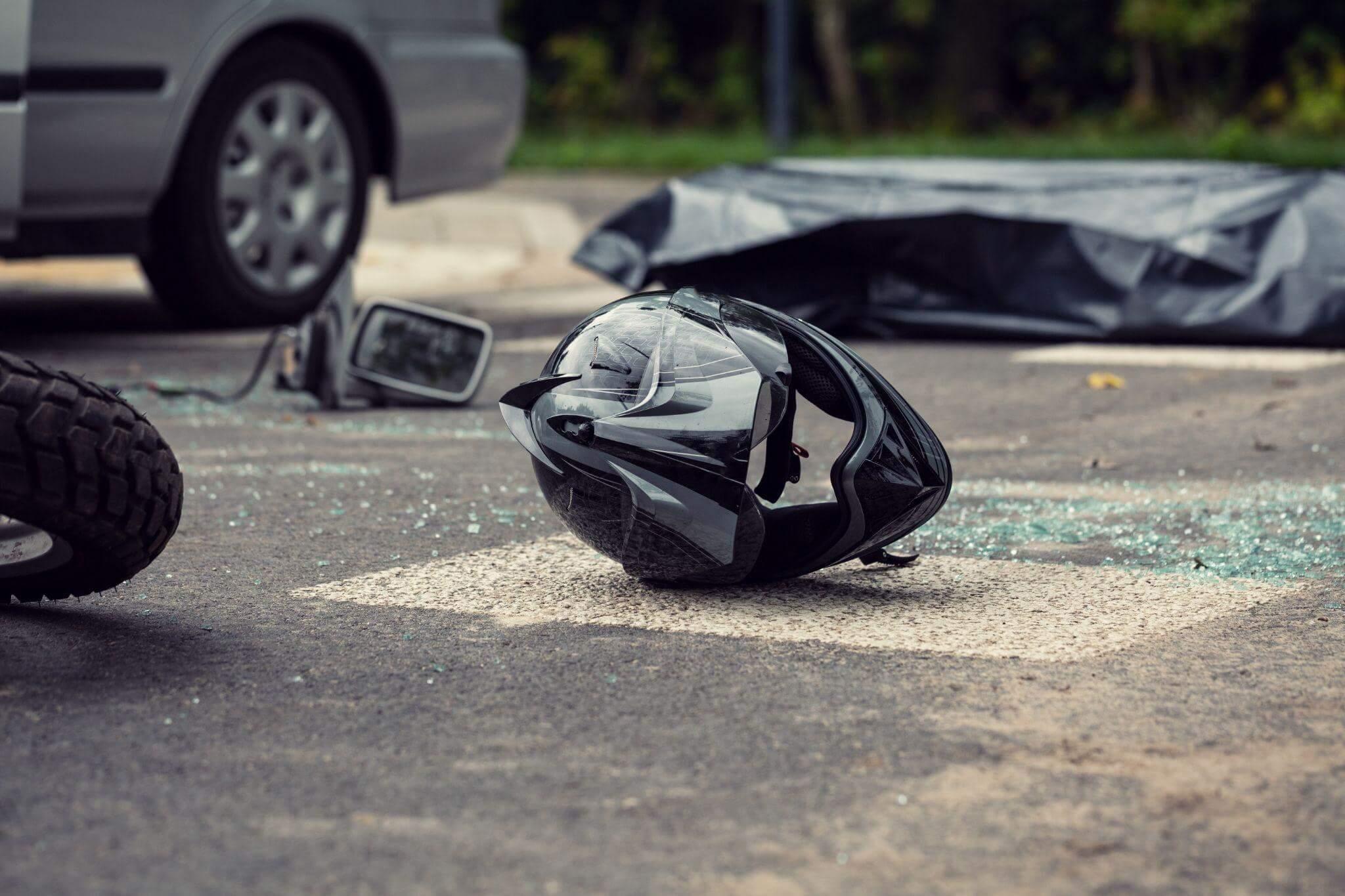 a motorcycle helmet on the ground next to a car